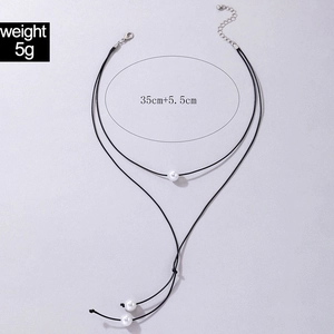 Detail of Y-shaped double layer choker necklace with white pearls and leather cord