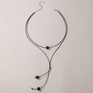 Detail of double-layer black cord Y-necklace with polished beads and silver lobster clasp