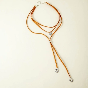 Detail of bohemian Y-shaped necklace with silver hammered charms and brown suede cord