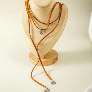 Detail of a brown suede cord Y-necklace with silver hollow circular pendant decorations