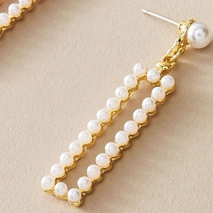 Boucles d'oreilles pendantes géométriques dorées avec incrustation de perles blanches