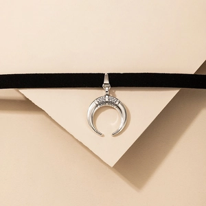 Close-up of black suede choker featuring a silver moon totem pendant with geometric patterns