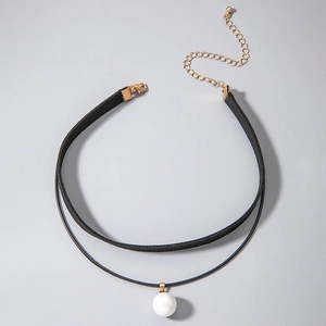 Close-up of double-layered black choker necklace with white pearl pendant and gold clasp