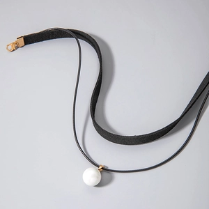 Detailed shot of double-layer black choker with pearl pendant and golden lobster clasp