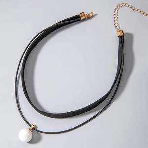 Close-up of double-layer black choker with white pearl pendant and gold lobster clasp