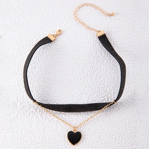 Detail of velvet choker featuring gold chains, black heart pendant, and adjustable clasp