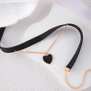 Detail of black velvet choker featuring a gold-edged heart pendant and adjustable chain