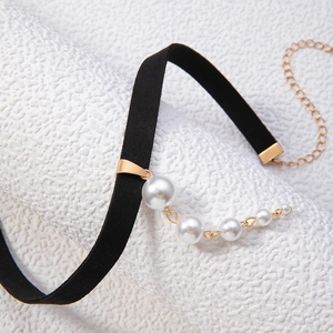 Detail of black velvet choker with five gradient white faux pearls and gold hardware