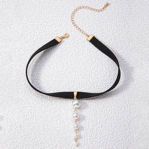 Detail of black choker necklace with cascading white pearls on a stone texture background