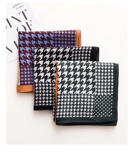 Detail of three houndstooth pattern square scarves in purple, black, and dark green colors