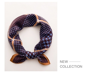 Detail of silk scarf showing blue houndstooth pattern and orange Fashion Modern border