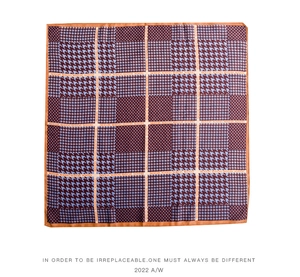 Detail of houndstooth silk scarf with orange hem and Fashion Modern lettering print
