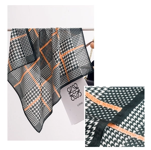 Detail view of houndstooth scarf with orange fashion stripes and woven texture
