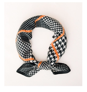 Detail of houndstooth silk scarf with orange border and modern fashion lettering