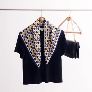 Navy and yellow geometric diamond print silk headscarf displayed on a hanger