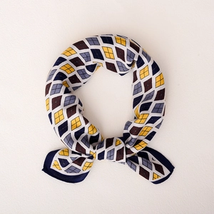 Navy and yellow geometric diamond print silk scarf tied in a stylish ring knot