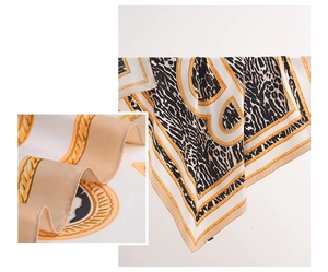 Detailed view of leopard print silk scarf with gold chain motifs and twill weave texture