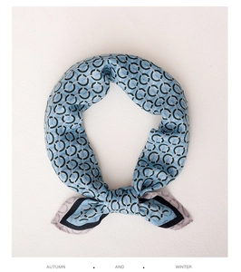 Detailed view of light blue silk square scarf featuring black chain link patterns
