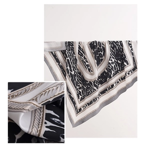 Detail of silk scarf showing leopard print pattern and smooth fabric texture close-up