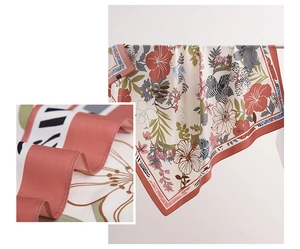 Detail eines korallenroten Seidentuchs mit elegantem Blumen- und Pflanzenmuster