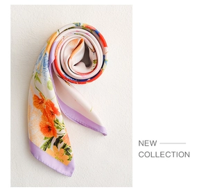 Detail eines Seidenschals mit orangefarbenen Blüten und lila genähten Kanten