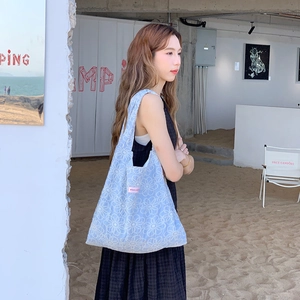 Gros plan du sac fourre-tout en tricot bleu clair avec broderie florale blanche