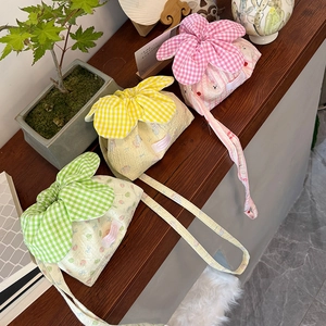 Close-up of cute floral plaid drawstring bags in pink yellow and green on wood
