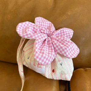 Close-up of flower-shaped drawstring bag with pink plaid petals and bear embroidery