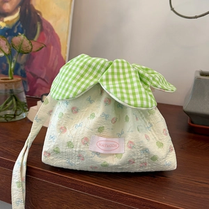 Detail of floral drawstring bag with fruit patterns and green checkered leaf design