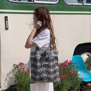 Photo extérieure d'un sac cabas en toile avec broderie florale et détails en dentelle