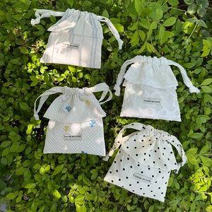 Detailed macro view of four drawstring pouches with lace trim and polka dot patterns