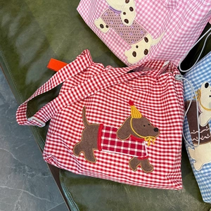 Détail de la broderie de teckel sur des sacs bandoulière à carreaux avec sangle réglable