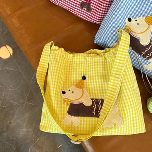 Détail du sac à bandoulière à carreaux jaunes avec écusson brodé de chiot mignon