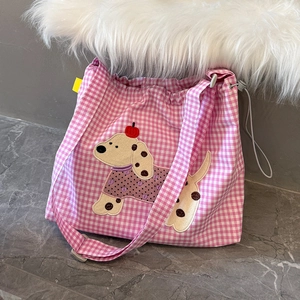 Détail du sac à carreaux rose avec broderie de chiot et cordon de serrage réglable
