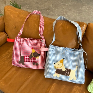 Détail de sacs bandoulière à carreaux avec broderie chiot et fermeture à cordon