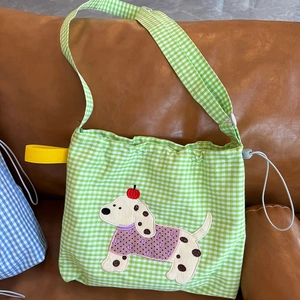 Détail du sac bandoulière à carreaux vert et blanc avec broderie chiot et cordon de serrage