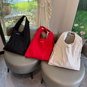 Sacs hobo en nylon noir, rouge et crème avec imprimé Camellia sur des sièges minimalistes