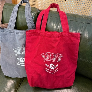 Detail of vintage washed canvas tote bags in red and blue with bohemian prints