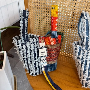 Detail of bohemian patchwork tote with fringe denim and ethnic geometric patterns