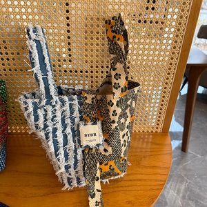 Detail of bohemian patchwork tote bag featuring denim fringe and animal print textures