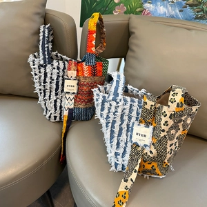 Detail of patchwork denim handbags with leopard print accents and tassel fringe details