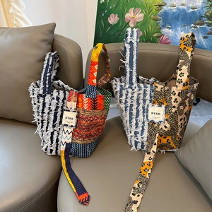 Detail of bohemian patchwork tote bags featuring frayed edges and ethnic pattern textures