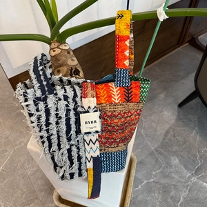 Detail of bohemian patchwork denim tote bag with tassel trim and geometric pattern texture