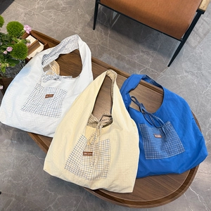 Vue détaillée des sacs cabas en toile avec des poches et une doublure à carreaux bleus