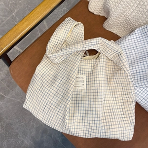 Gros plan détaillé sur le sac cabas à carreaux bleu et blanc avec étiquette magazine