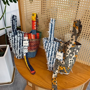 Bohemian patchwork canvas tote bag with tassels and ethnic prints in natural studio setting