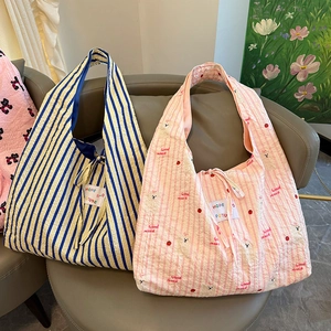Detail of cute striped tote bags with bear print and Hope Future patch on a chair