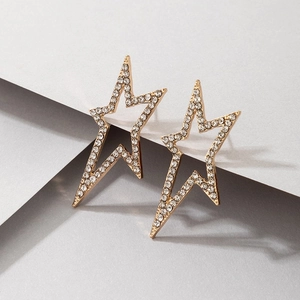 Detail of gold geometric hollow star earrings with pavé set white crystals