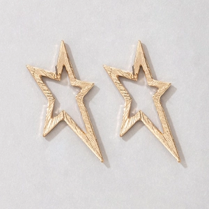 Detailed macro view of gold-colored star-shaped stud earrings with brushed metal texture
