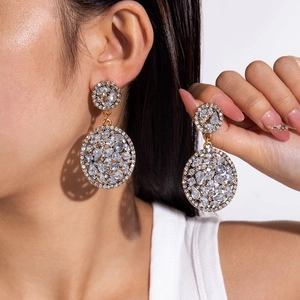 Close-up of gold geometric earrings with pavé crystals in a luxury chandelier style